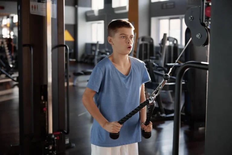 Youngster in the gym with pull down rope