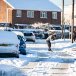 Man shovelling snow on a wintry day