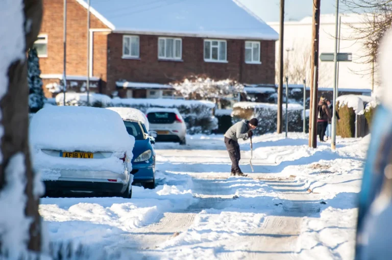 Man shovelling snow on a wintry day