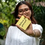 Women holding a note with quotes Believe in yourself