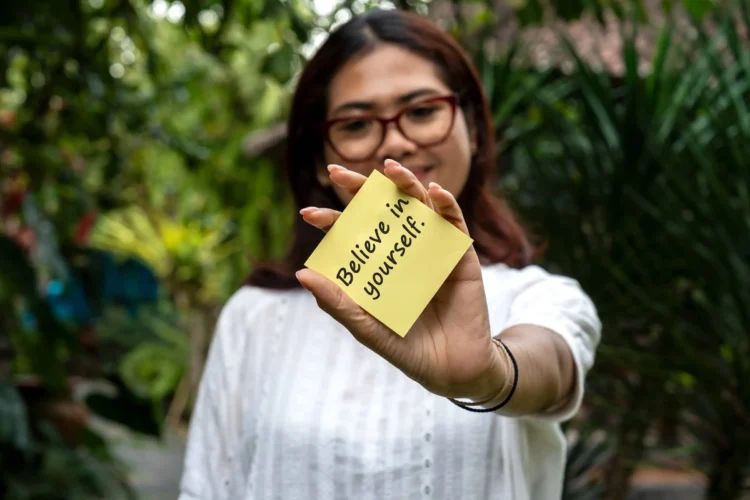 Women holding a note with quotes Believe in yourself