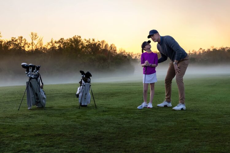 Young Golfer with Parent on golf course