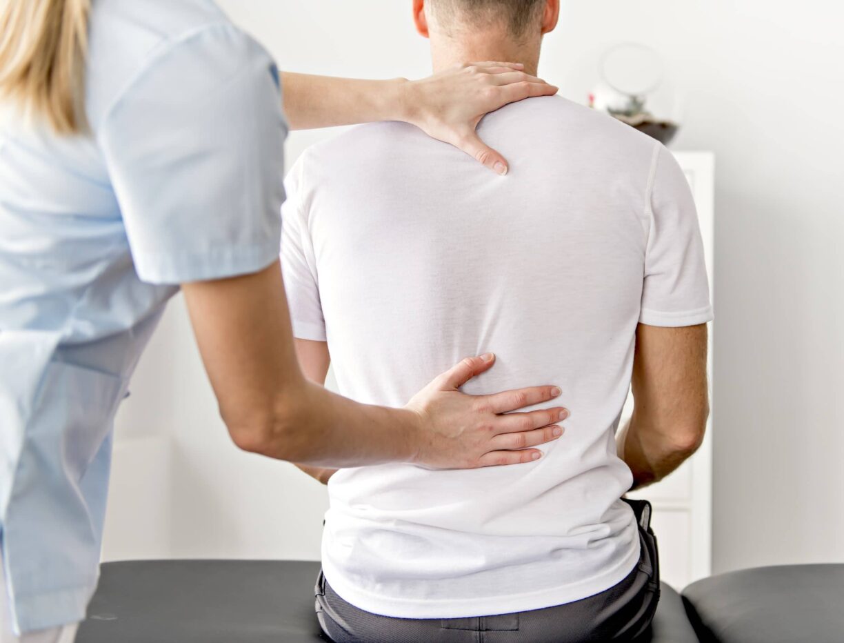A Patient at the physiotherapy doing physical exercises with his therapist