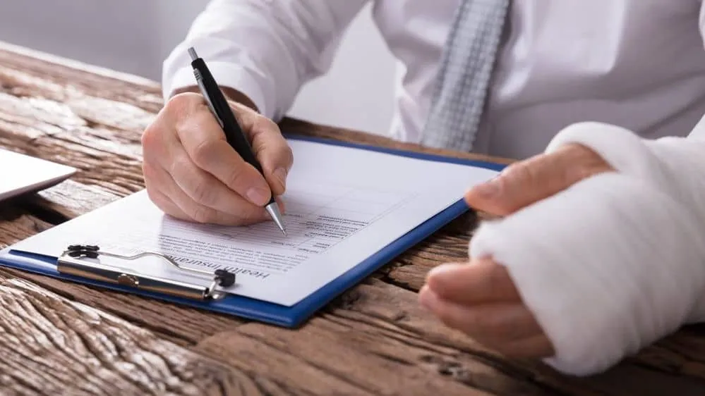 Person writes with one hand and the other hand bandaged