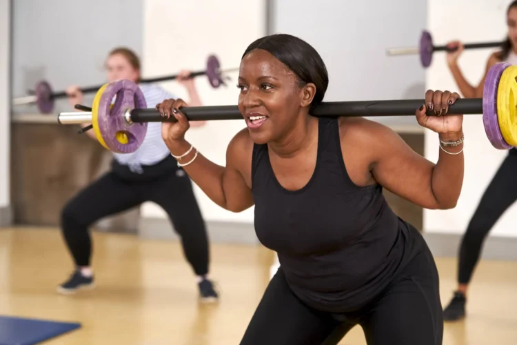 Women doing barbell workout