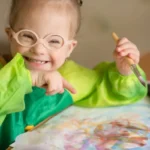 Young child smiling and painting
