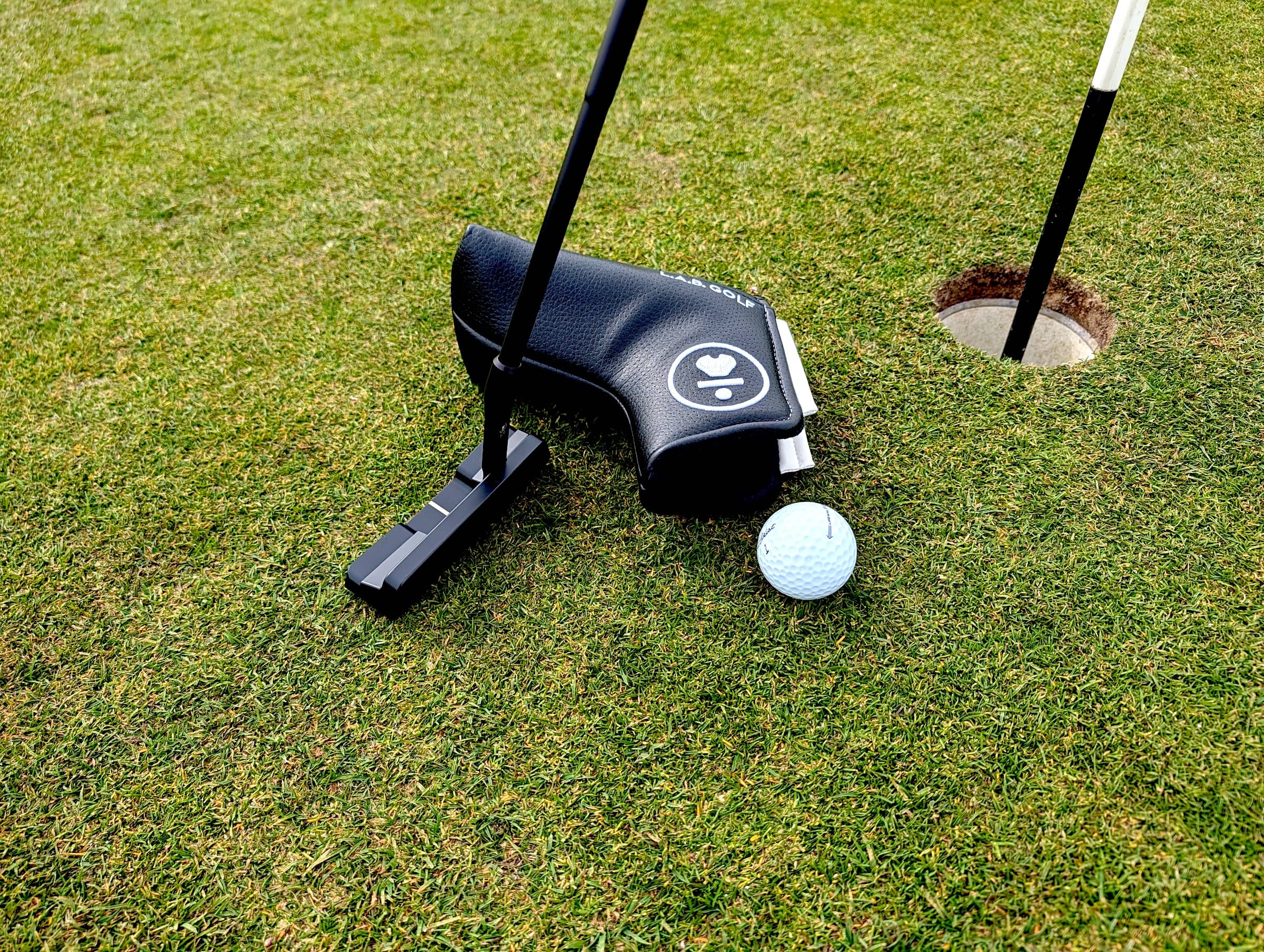 L.A.B Golf Link 2.1 Putter on the green with cover