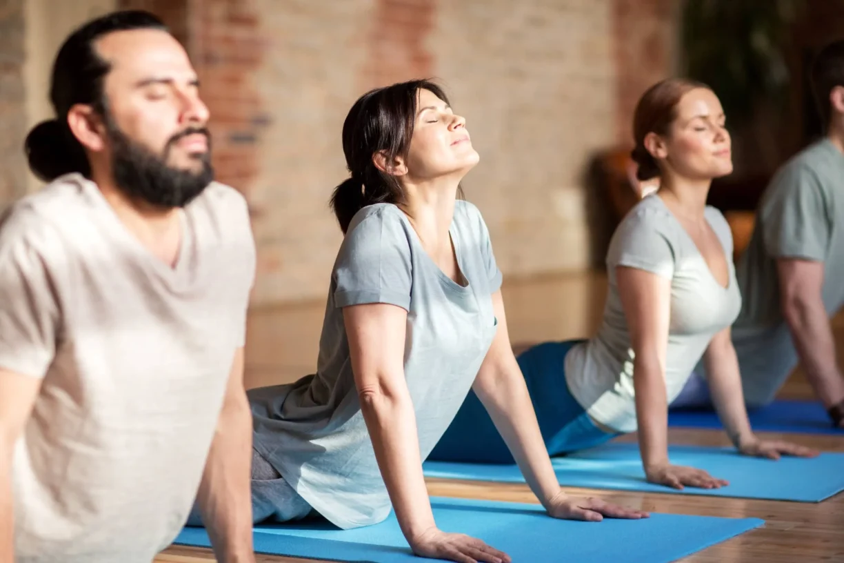 group of people doing yoga dog pose at studio