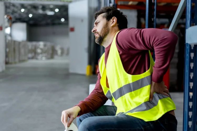 Worker holds his back in pain
