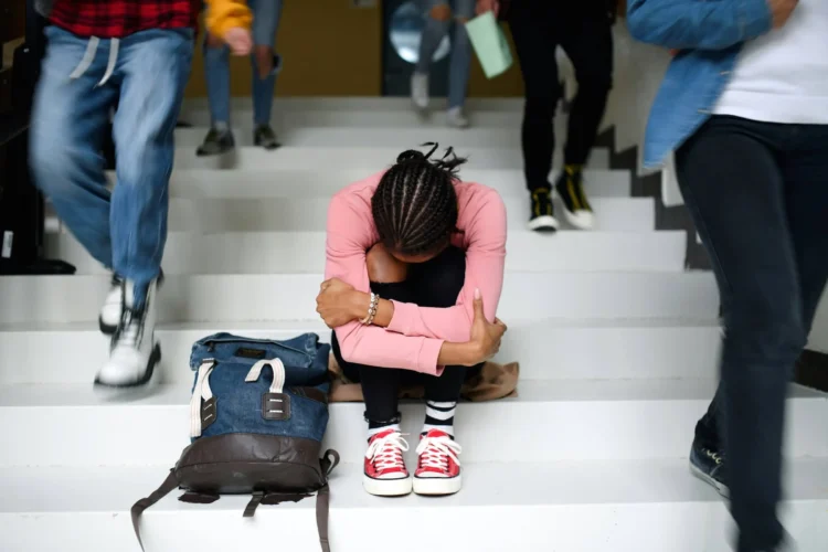 Young Person Sits on Stairs with Head Down
