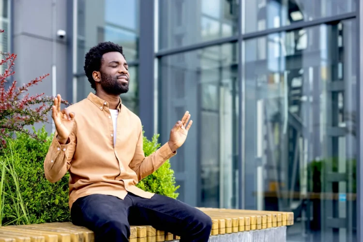 Young man finding inner peace and mindful balance by meditating outdoors