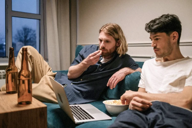 Young men watch something on a laptop