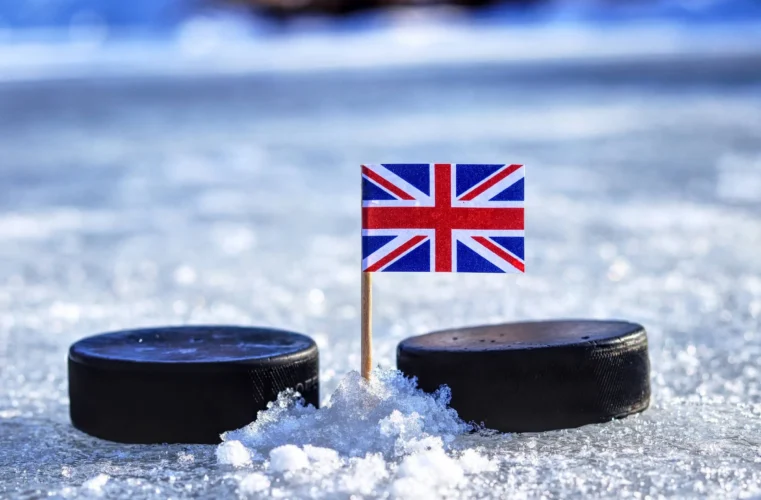 A british flag on toothpick between two hockey pucks on ice in winter classic