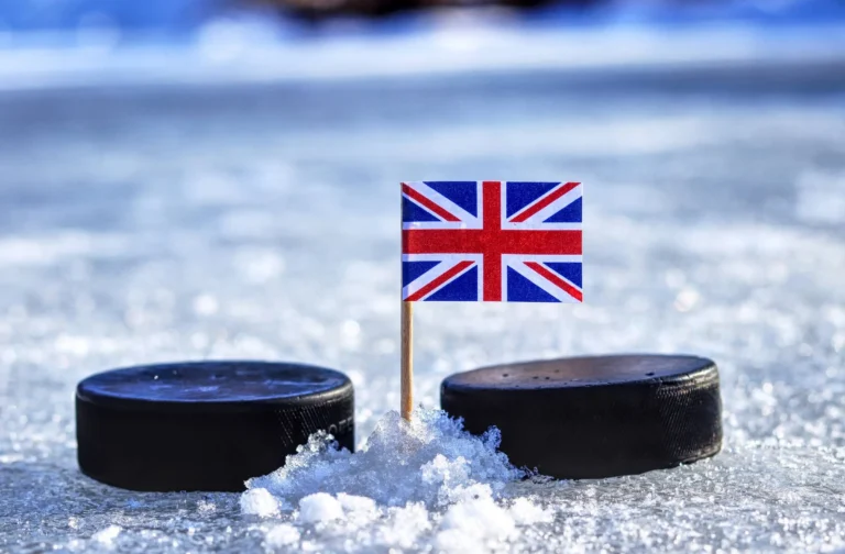 A british flag on toothpick between two hockey pucks on ice in winter classic