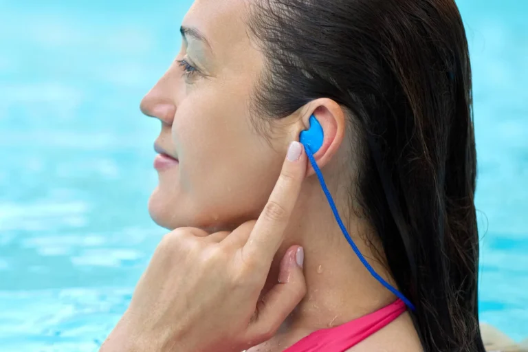 Close-up view of a woman using individual earplugs while swimming