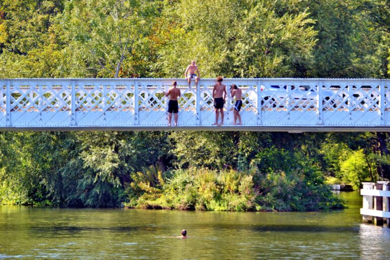 Group of teenagers ready to jump off a bridge into a river