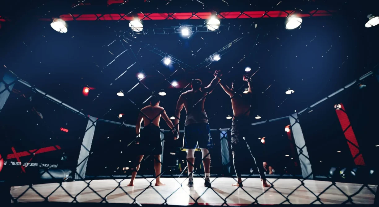 Referee raises hand to fighter winner of fights without rules in cage octagon