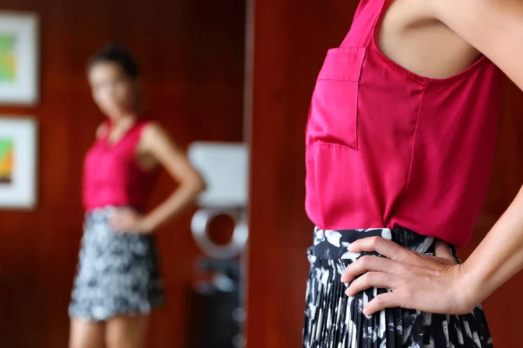 Woman trying clothing looking at the mirror