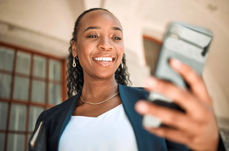 Woman with phone looks and smiles
