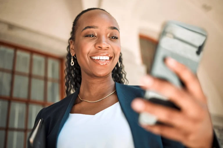 Woman with phone looks and smiles