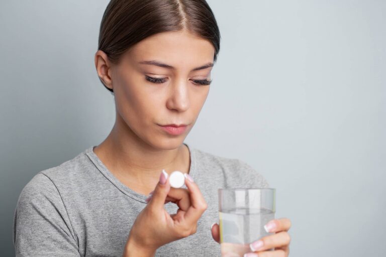 Woman taking pill with water