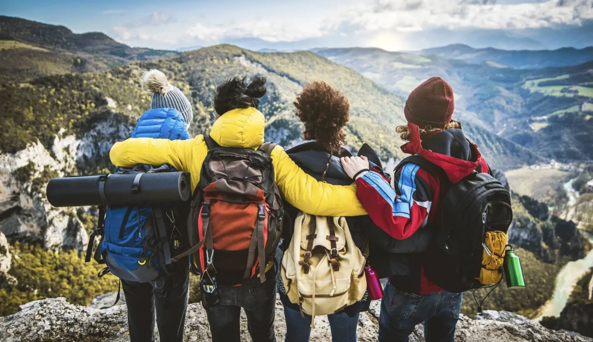 Women huddle whilst overlooking mountains