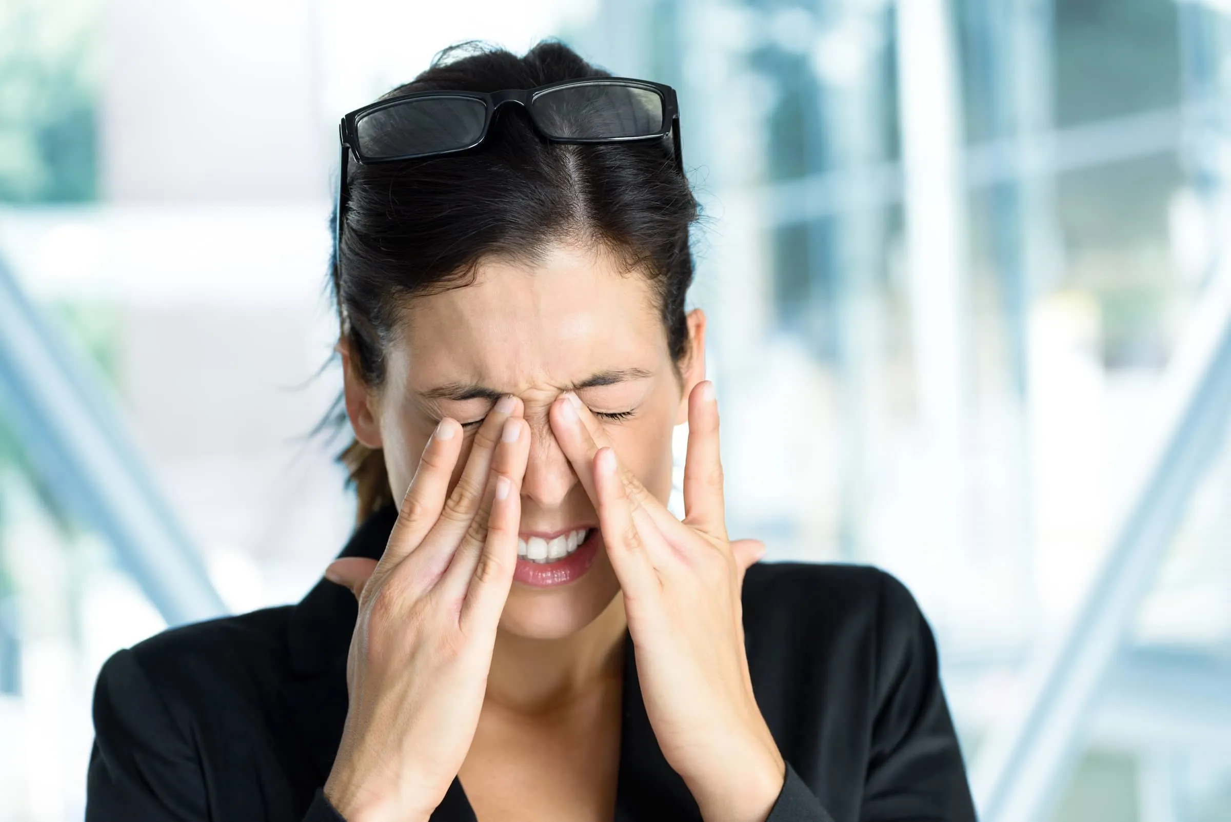 Business woman with tired sore eyes and stress