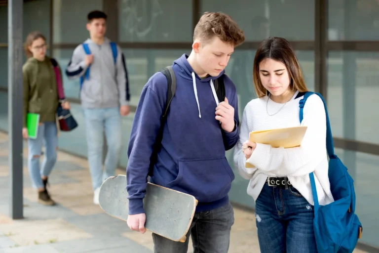 Teenage boy and girl discuss homework after college lessons