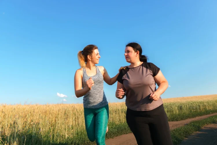 Young fit woman support and motivate her overweight female friend