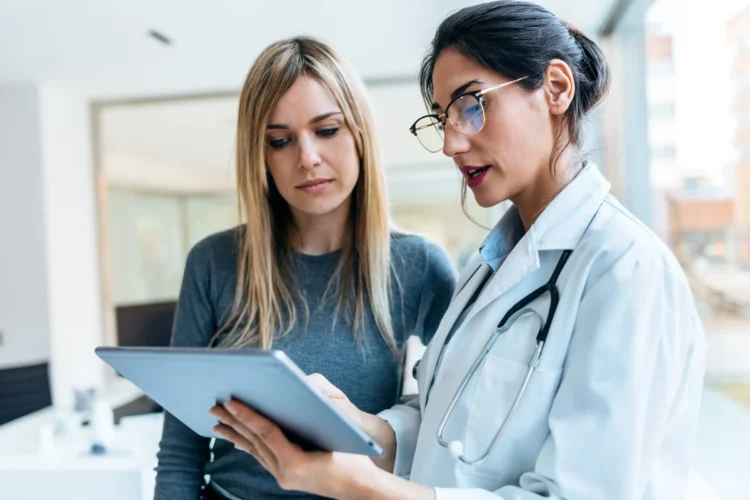 female doctor talking while explaining medical treatment with digital tablet to patient