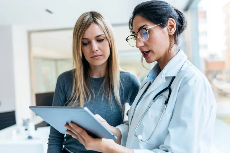 female doctor talking while explaining medical treatment with digital tablet to patient