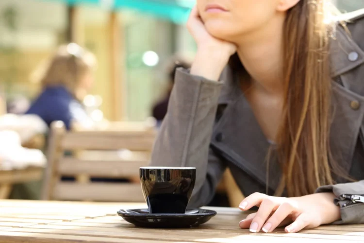Impatient woman waiting on a cafe terrace for late friend