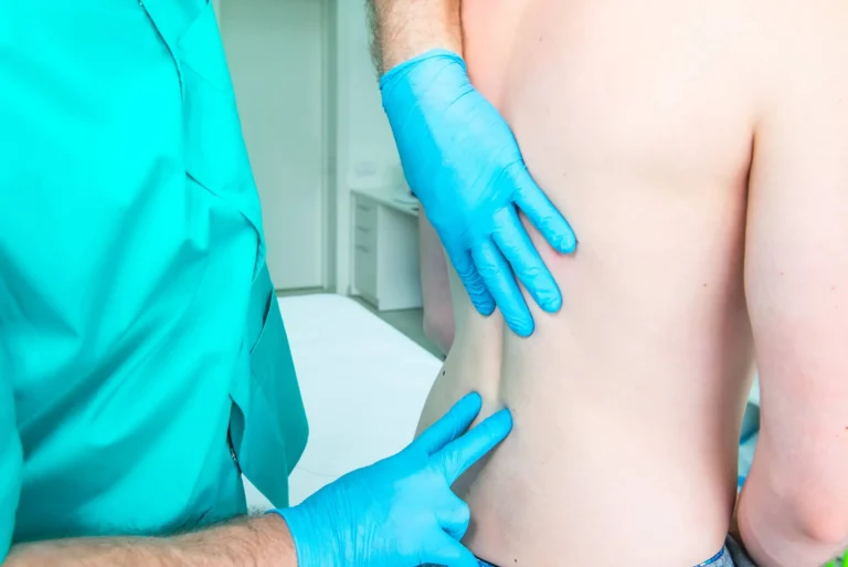 Neurologist doctor diagnoses the lumbar spine of male patient
