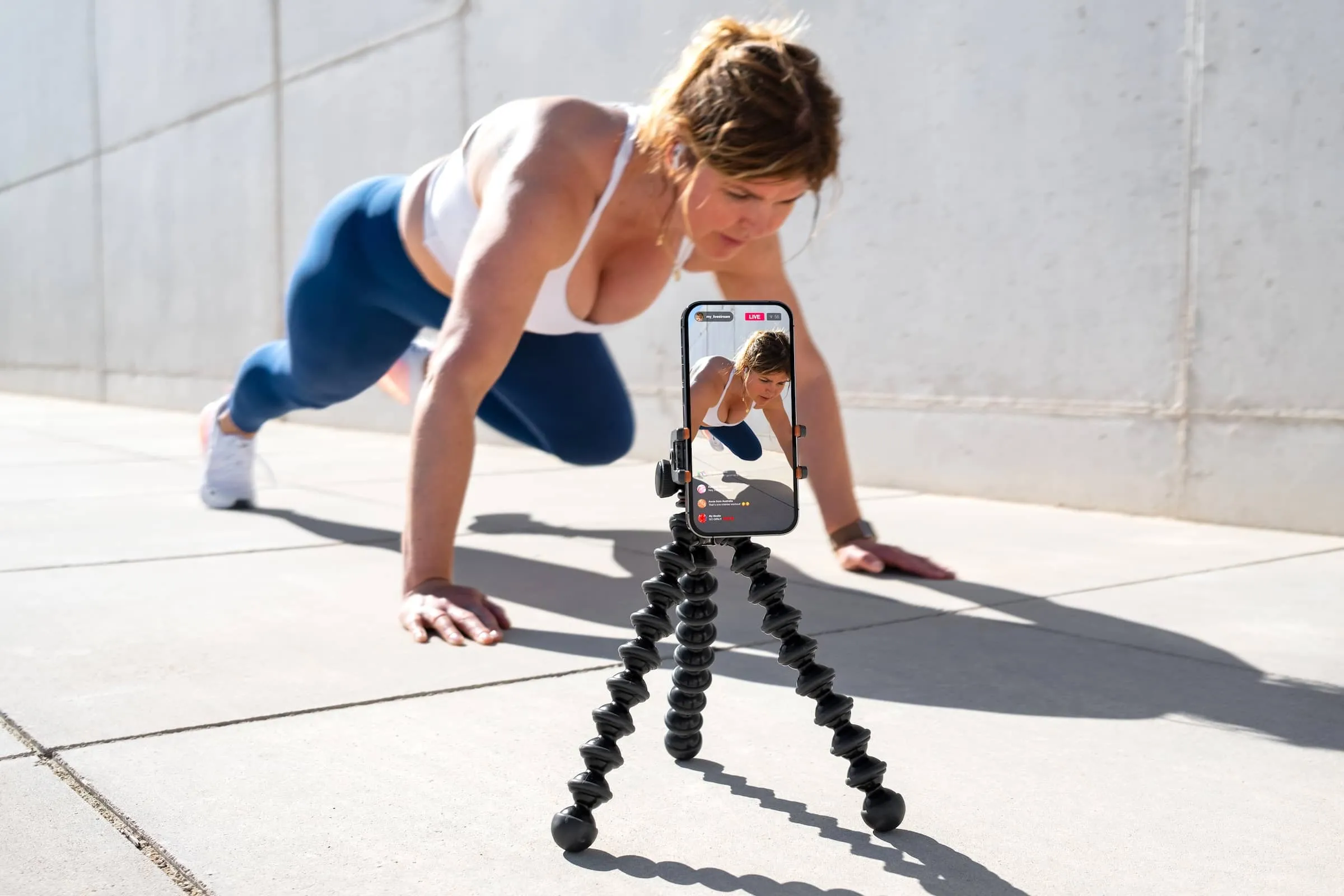 Woman films herself on mobile phone and live streaming her fitness workout on social media